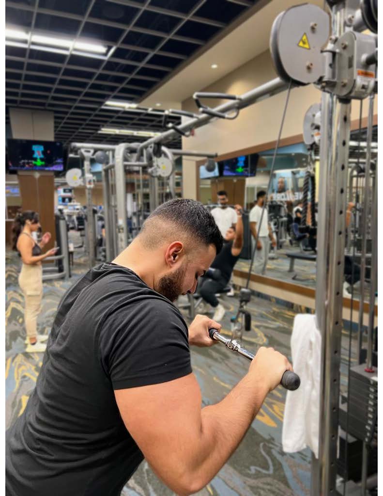 Sepehr training triceps on the cable stack in the gym